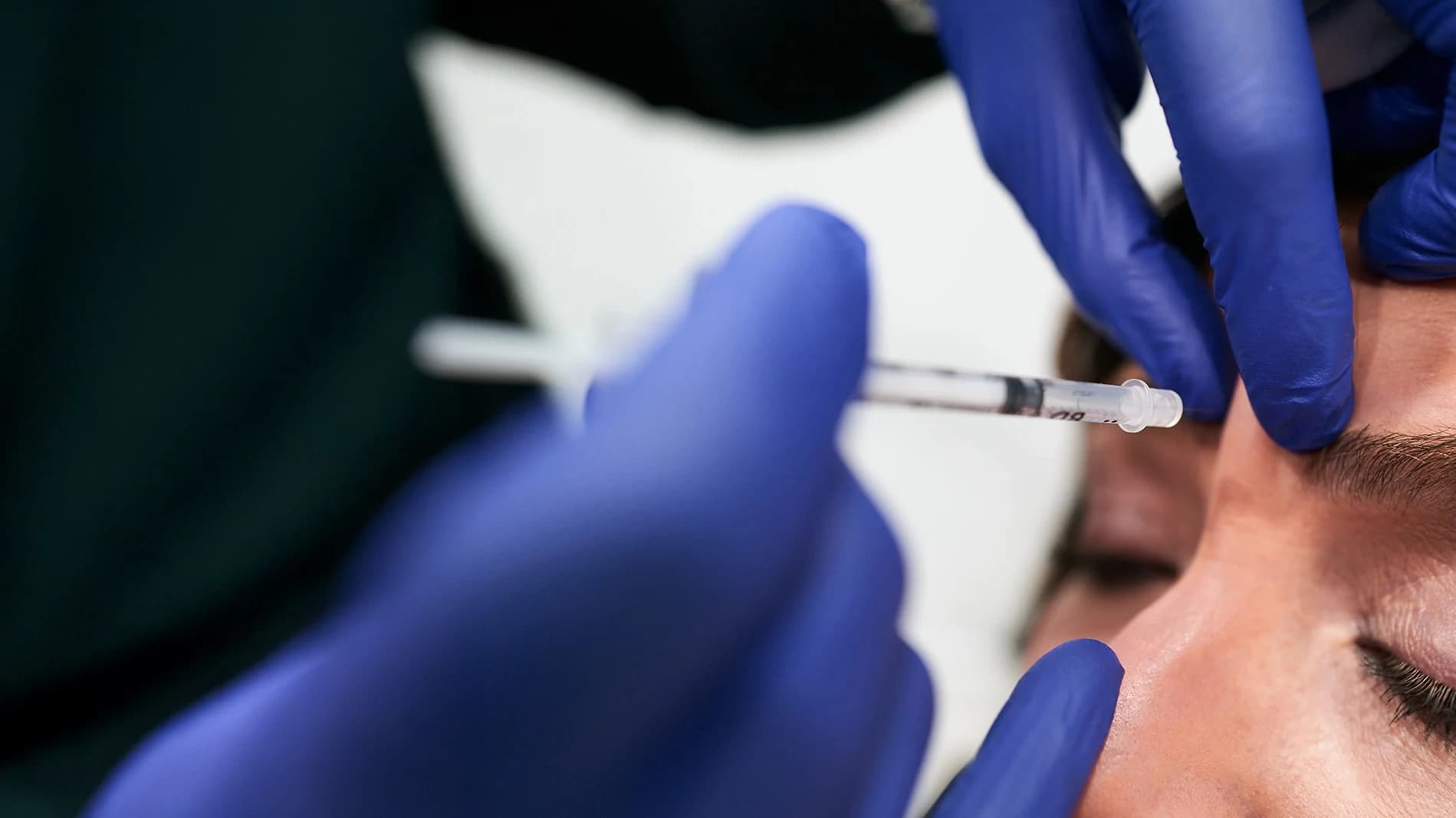 Patient getting injections in between her eyebrows