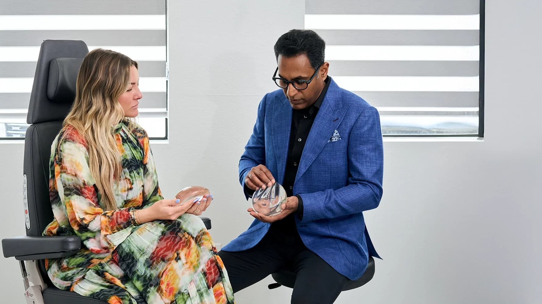 Dr. Solomon showing a patient examples of breast implants