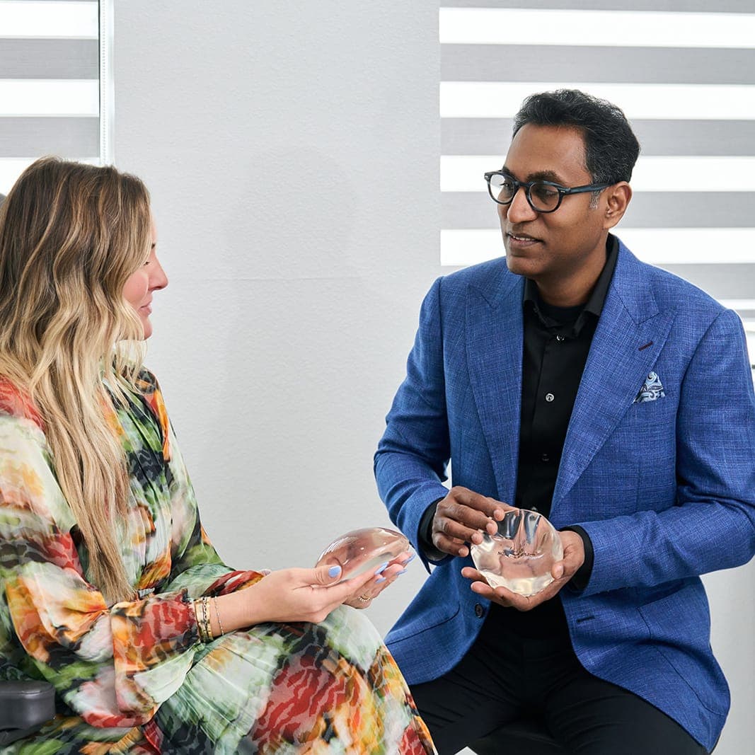 Dr. Solomon showing a breast implant to a patient.