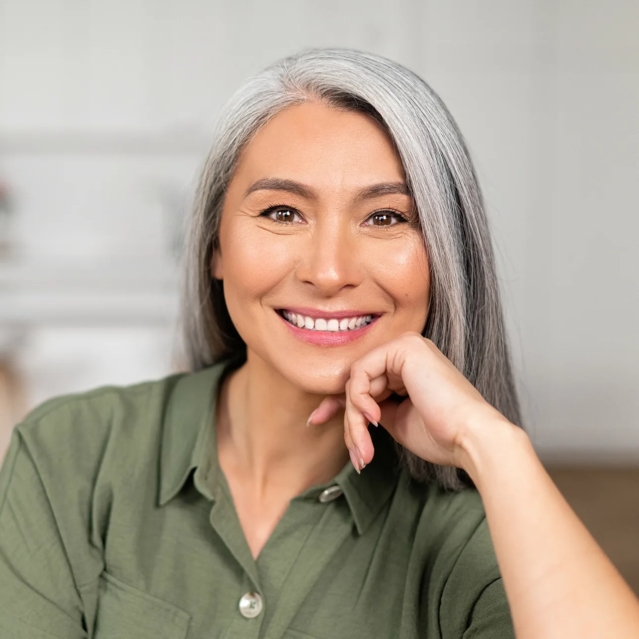 Stock woman with green shirt and gray hair smiling