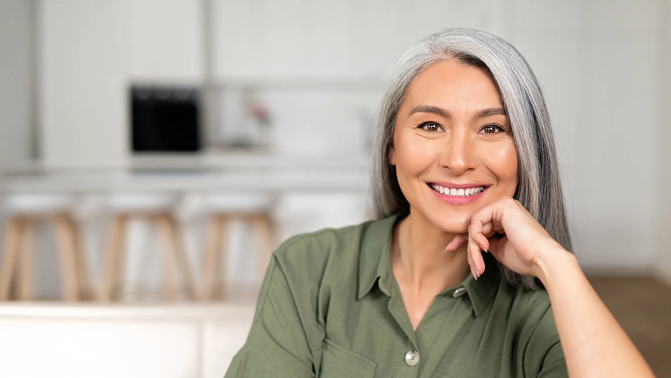 Stock woman with green shirt and gray hair smiling