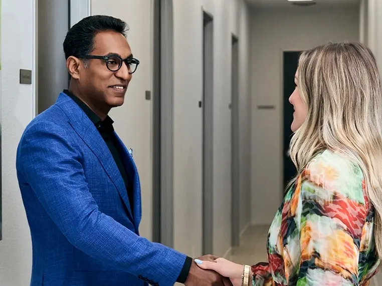 Dr. Solomon shaking hands with his happy patient at his practice in Frisco, Texas