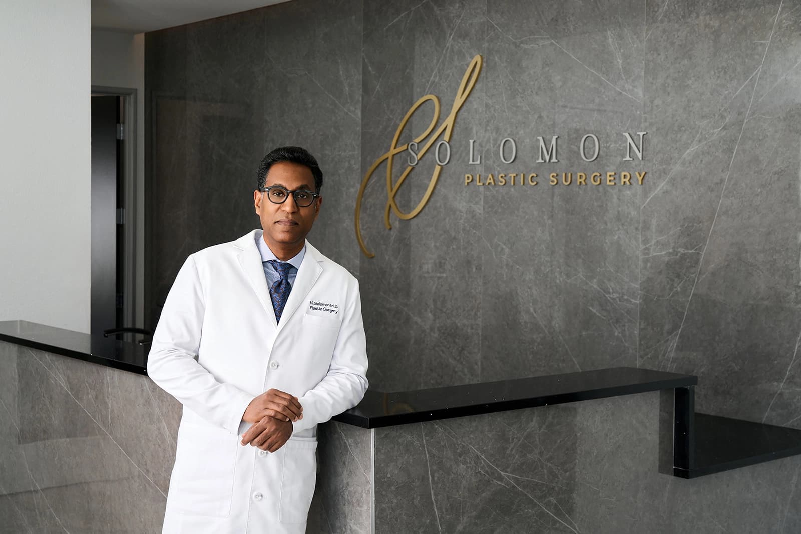 Dr. Matthias Solomon wearing a lab coat in his practice in Frisco TX