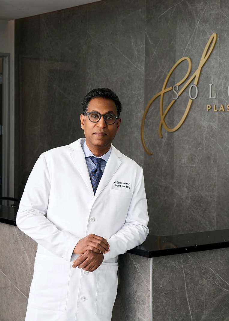 Dr. Matthias Solomon wearing a lab coat in his practice in Frisco TX
